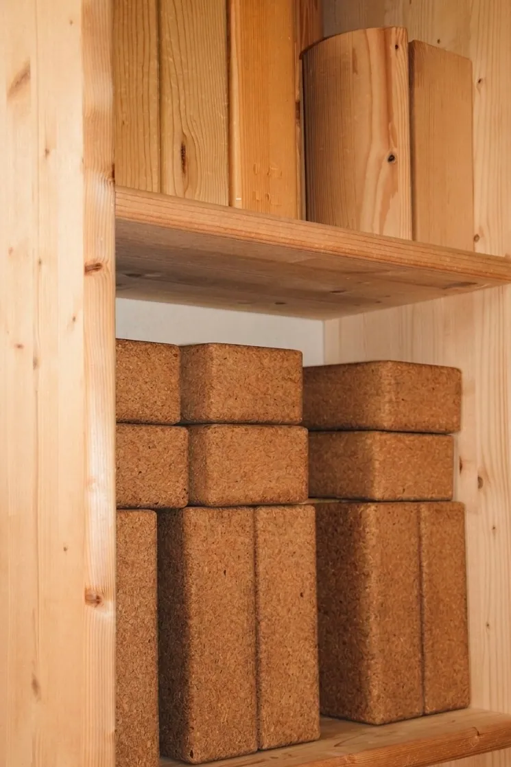 Mattoncini di sughero da yoga sullo scaffale dello studio · Yoga Tribù